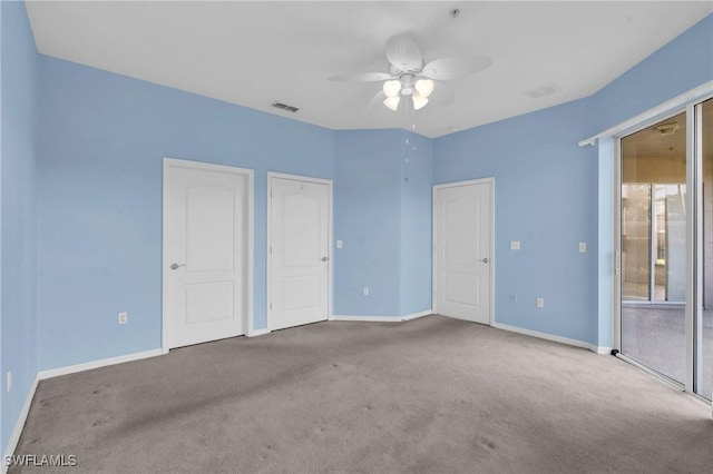 unfurnished bedroom with ensuite bath, two closets, ceiling fan, and light carpet