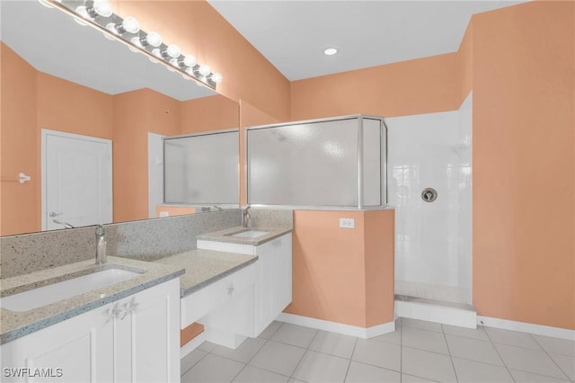 bathroom with tile patterned flooring, tiled shower, and vanity