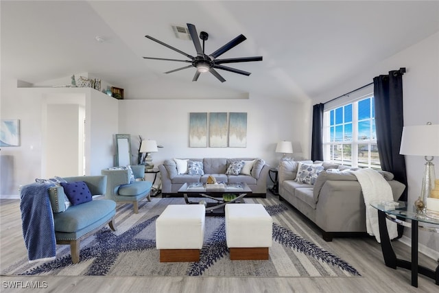 living room with ceiling fan, light hardwood / wood-style floors, and vaulted ceiling