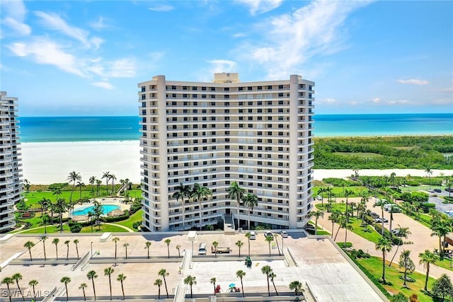 view of building exterior featuring a water view and a view of the beach