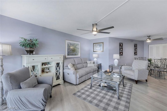 living room with ceiling fan and light hardwood / wood-style flooring