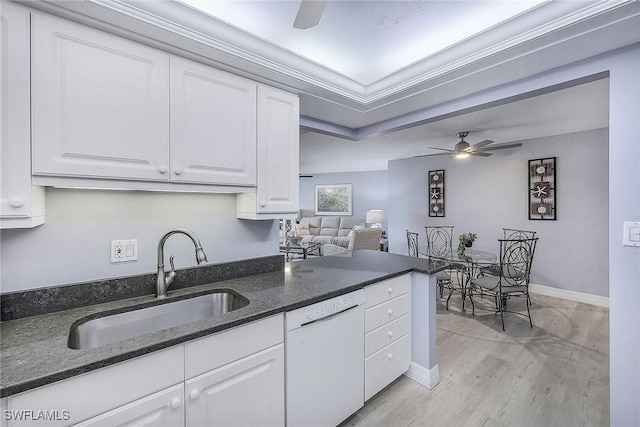 kitchen with white dishwasher, white cabinets, crown molding, and sink