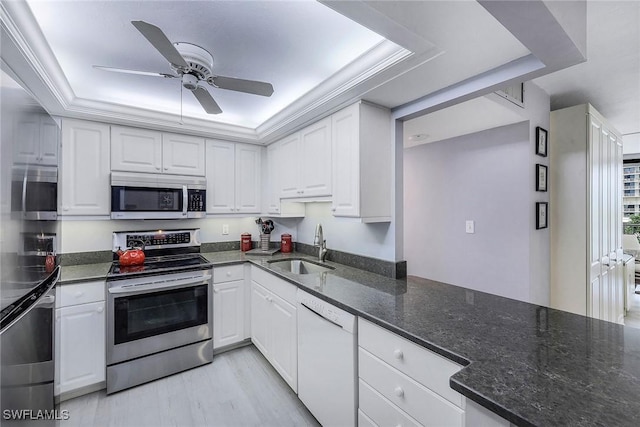 kitchen featuring appliances with stainless steel finishes, white cabinets, and a raised ceiling