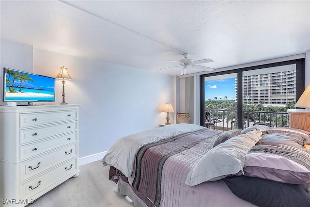 bedroom featuring floor to ceiling windows, ceiling fan, access to exterior, and light hardwood / wood-style floors