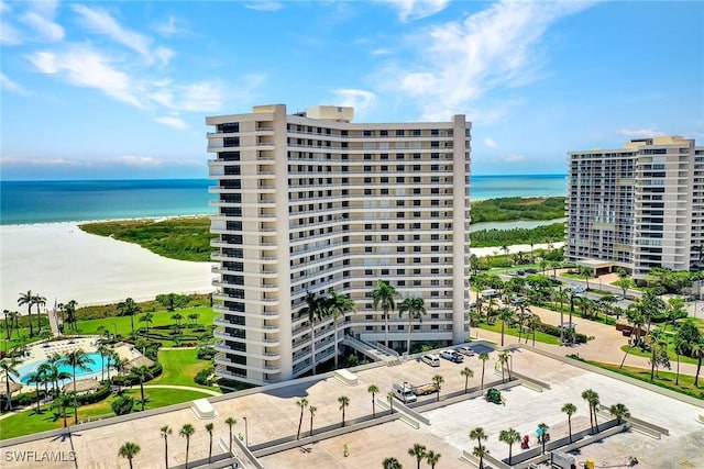 view of building exterior featuring a beach view and a water view