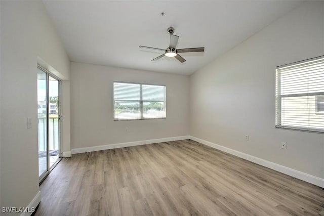 spare room featuring ceiling fan, lofted ceiling, and light wood-type flooring