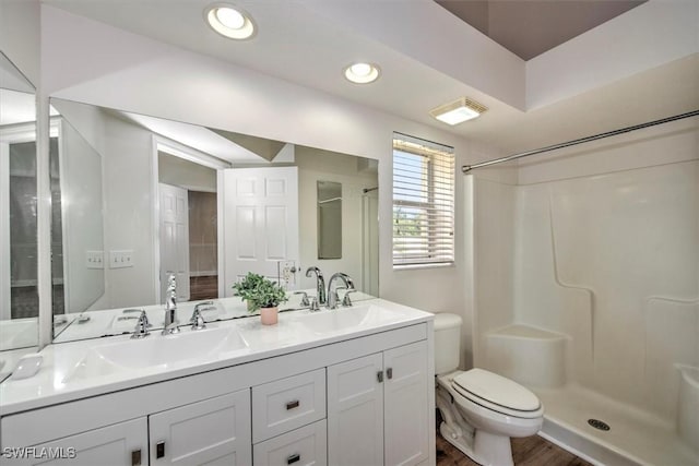 bathroom with wood-type flooring, toilet, walk in shower, and vanity