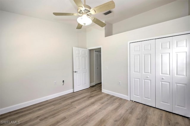 unfurnished bedroom with ceiling fan, a closet, and light wood-type flooring