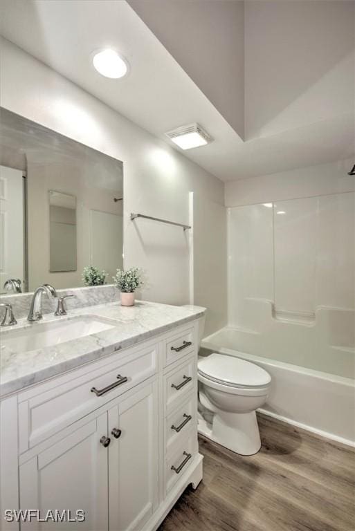 full bathroom featuring bathtub / shower combination, hardwood / wood-style floors, toilet, and vanity