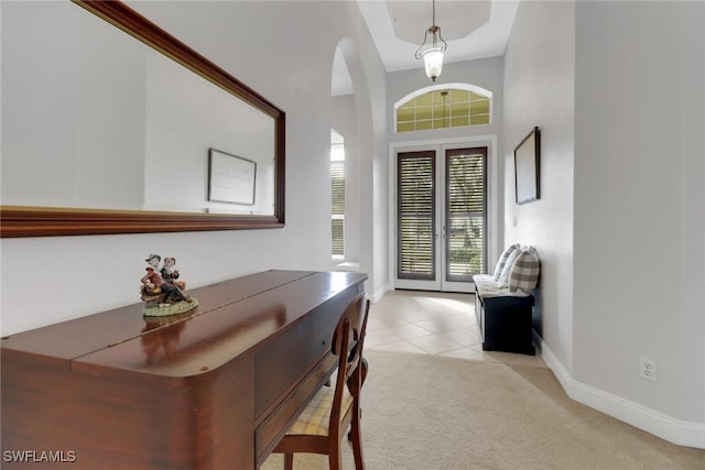 foyer entrance featuring light carpet and french doors