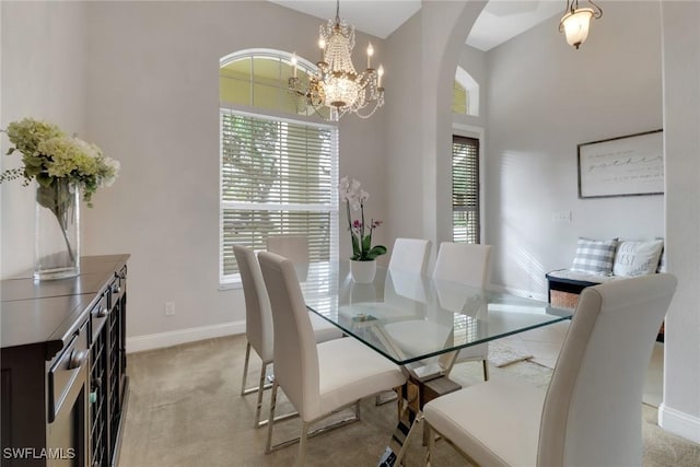 carpeted dining area featuring an inviting chandelier