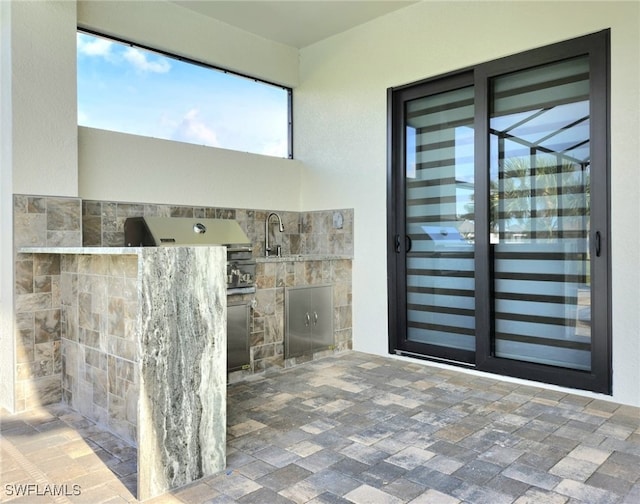 view of exterior entry featuring sink and an outdoor kitchen