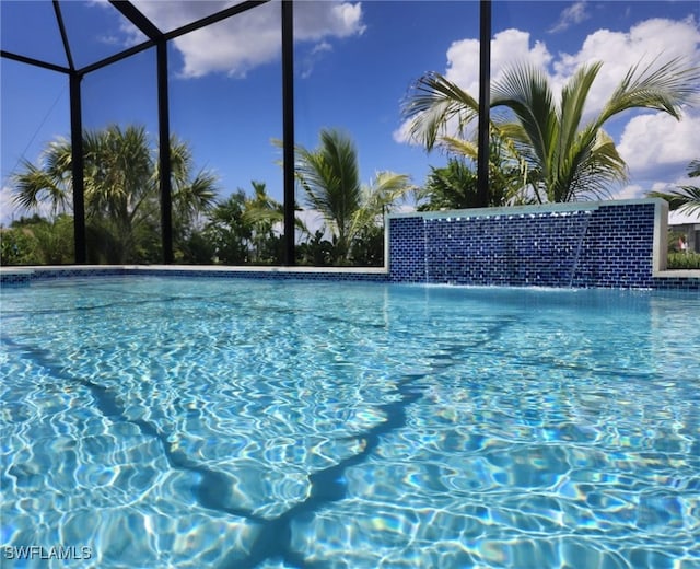 view of swimming pool featuring a lanai and pool water feature