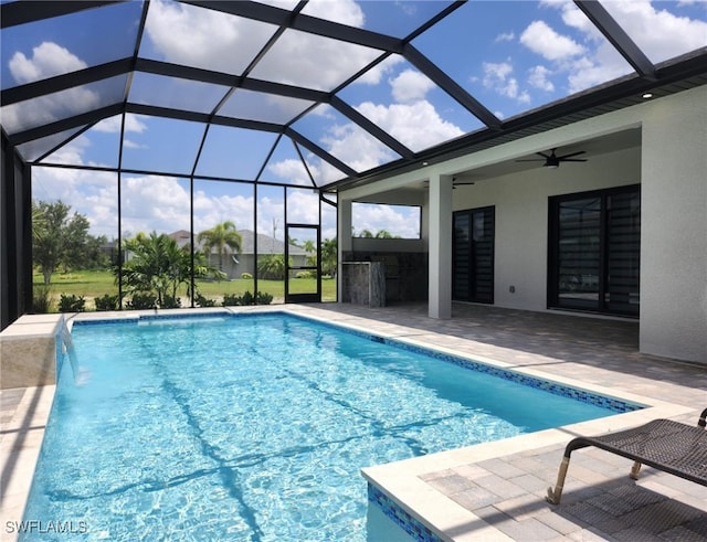 view of swimming pool featuring a patio area, a bar, glass enclosure, ceiling fan, and pool water feature