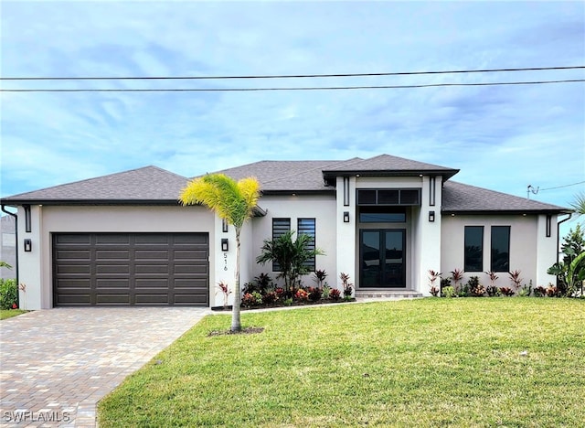 prairie-style home featuring french doors, a front lawn, and a garage