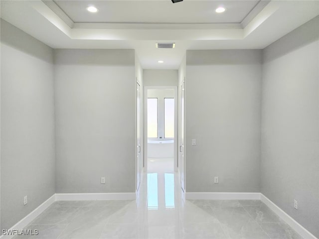 unfurnished room featuring a raised ceiling