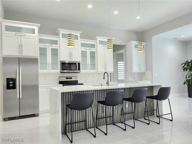 kitchen featuring appliances with stainless steel finishes, pendant lighting, a kitchen bar, and sink