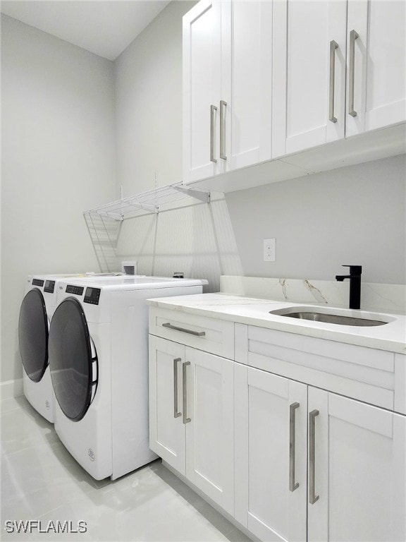 washroom with sink, cabinets, and separate washer and dryer