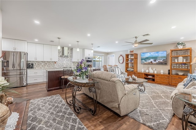 living room with ceiling fan and dark wood-type flooring