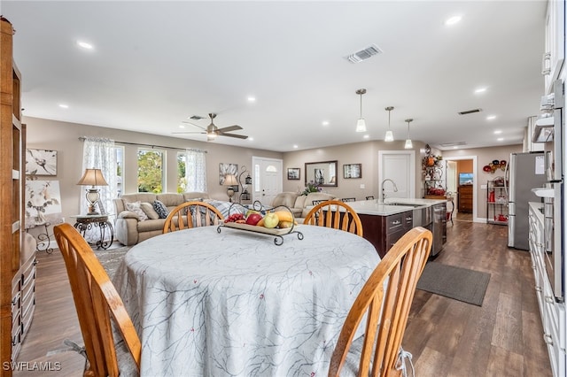 dining space featuring ceiling fan, dark hardwood / wood-style floors, and sink