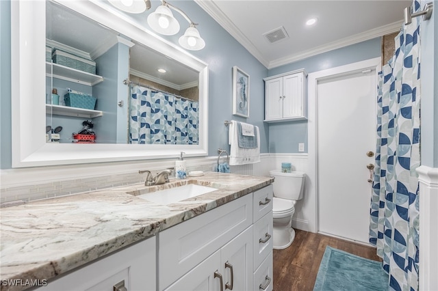 bathroom with toilet, vanity, ornamental molding, and hardwood / wood-style flooring