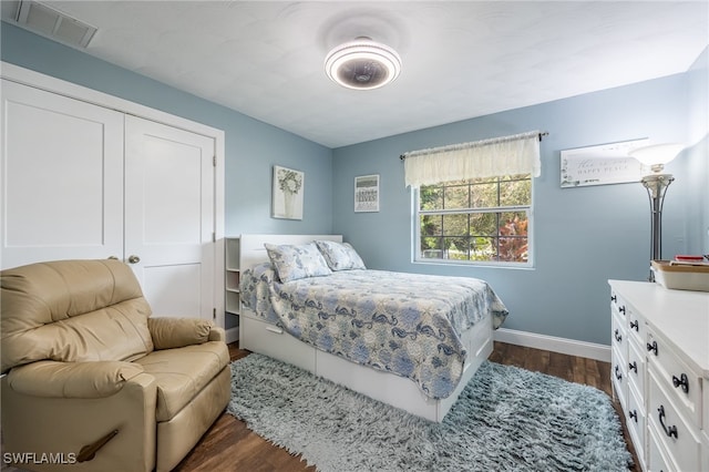 bedroom with dark wood-type flooring and a closet