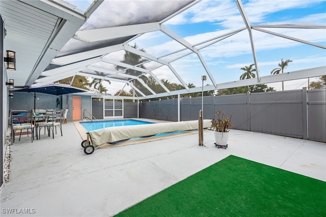 view of pool featuring a lanai, a patio area, and a storage shed