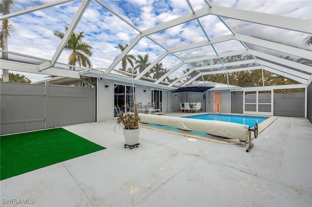 view of swimming pool with a lanai and a patio