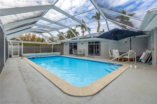 view of pool with a patio and glass enclosure