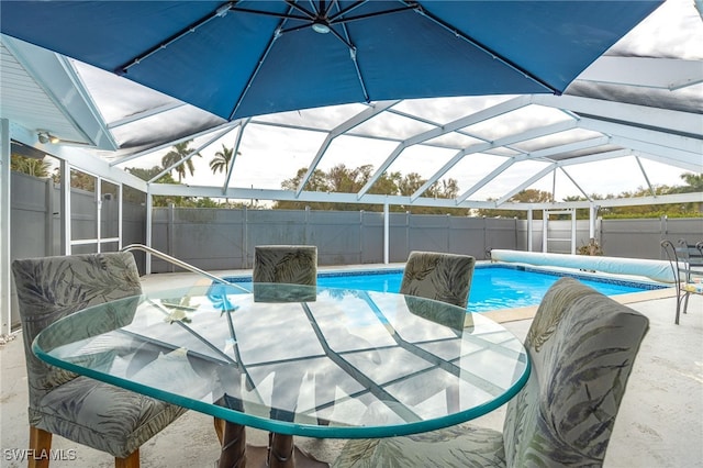 view of swimming pool featuring glass enclosure