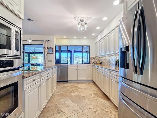 kitchen featuring light stone countertops, appliances with stainless steel finishes, and plenty of natural light