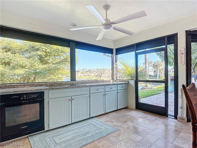 kitchen with gray cabinets, oven, and ceiling fan