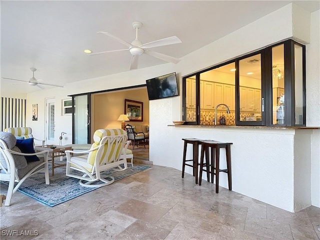 living room with ceiling fan and sink