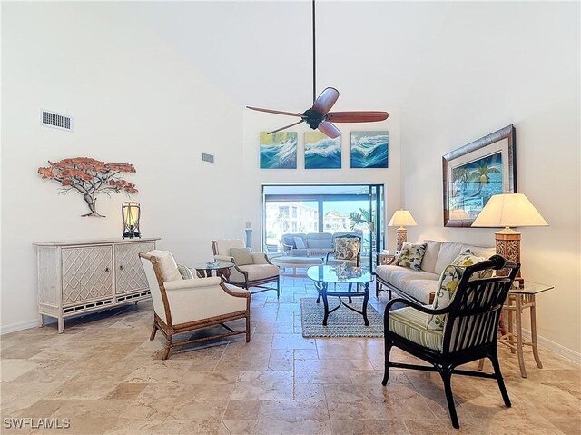 living room with ceiling fan and a high ceiling