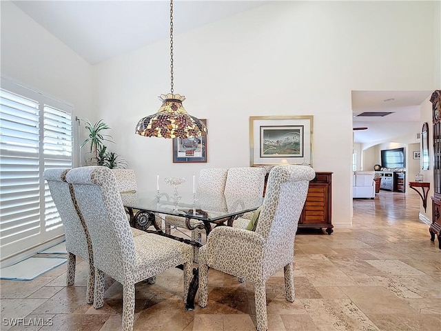 dining room featuring high vaulted ceiling