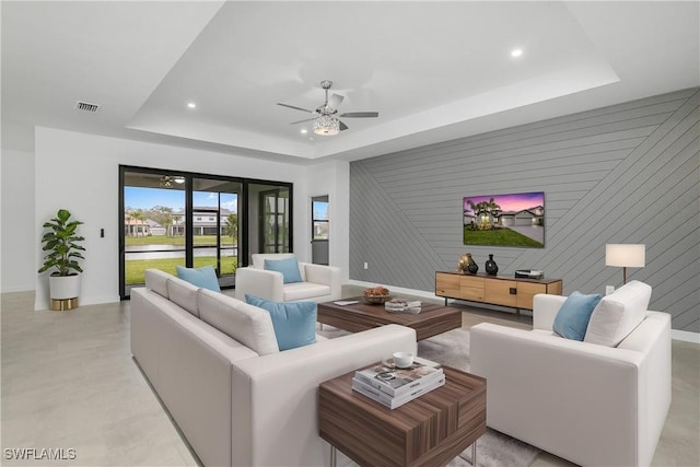 living room with visible vents, a raised ceiling, a ceiling fan, and recessed lighting