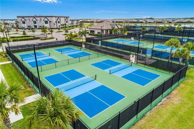 view of tennis court featuring fence and a residential view