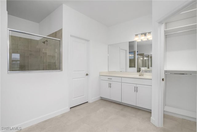 full bath featuring a shower stall, baseboards, and vanity