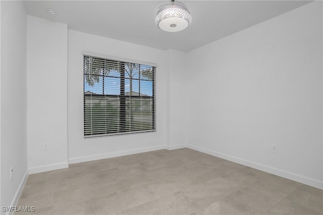 unfurnished room with baseboards