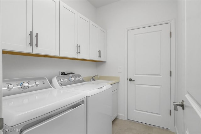 clothes washing area with cabinet space, separate washer and dryer, a sink, and light tile patterned flooring