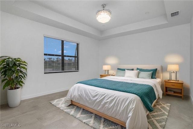 bedroom with a raised ceiling, visible vents, and baseboards