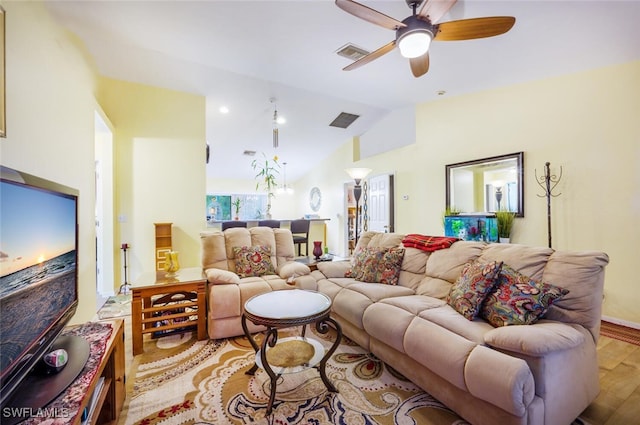 living room featuring ceiling fan, light hardwood / wood-style floors, and vaulted ceiling