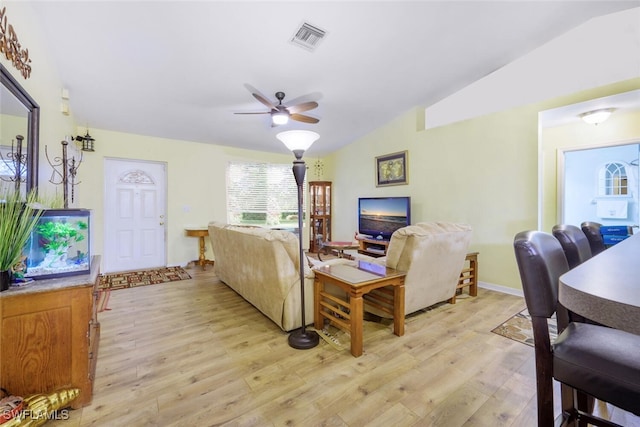 living room featuring ceiling fan, light wood-type flooring, and vaulted ceiling