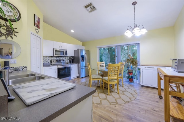 kitchen with sink, white cabinets, an inviting chandelier, decorative backsplash, and appliances with stainless steel finishes