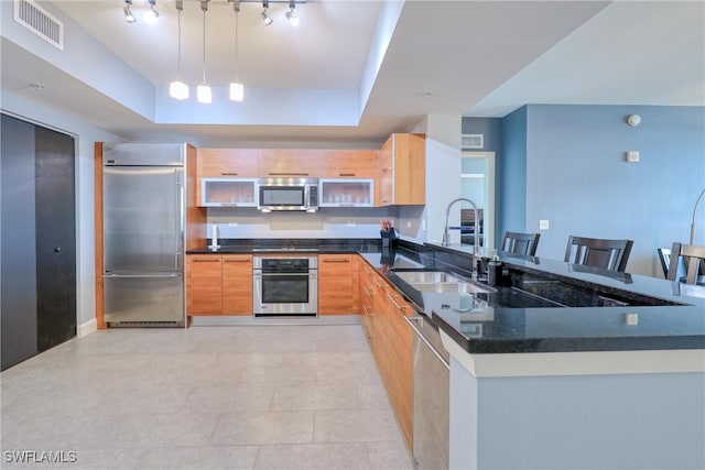 kitchen featuring stainless steel appliances, a kitchen bar, pendant lighting, and kitchen peninsula