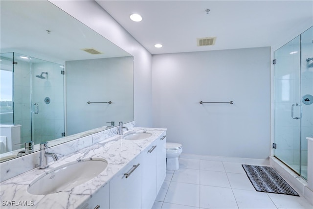 bathroom featuring vanity, tile patterned floors, a shower with shower door, and toilet