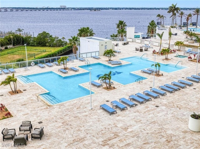 view of pool featuring a water view and a patio area