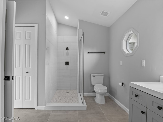 bathroom with tile patterned floors, toilet, vanity, and a tile shower