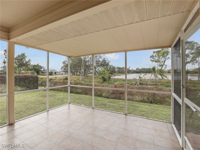 unfurnished sunroom featuring a water view