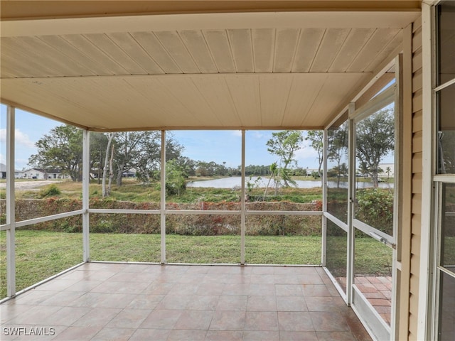 unfurnished sunroom featuring a water view